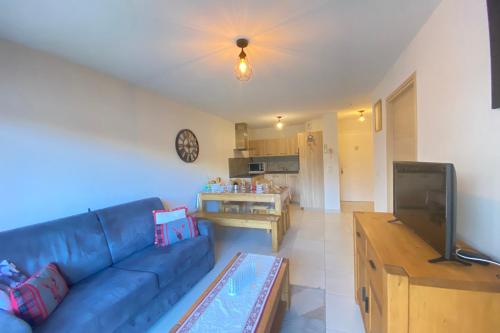 un salon avec un canapé bleu et une cuisine dans l'établissement Luxury apartment close to the slopes, à Saint-Étienne-en-Dévoluy
