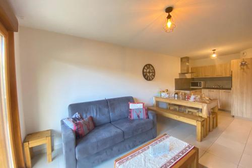 un salon avec un canapé bleu et une cuisine dans l'établissement Luxury apartment close to the slopes, à Saint-Étienne-en-Dévoluy