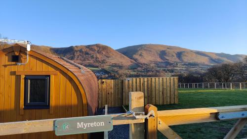 a wooden building with a mountain in the background at Devonknowes lodges in Tillicoultry