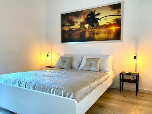 a white bedroom with a large bed with two lamps at La Cementina sul mare in Bari