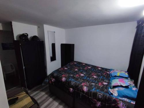 Precioso apartamento completo con tina y equipado في Soacha: غرفة نوم صغيرة مع سرير وخزانة