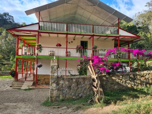 une maison avec des fleurs devant dans l'établissement Casa Altozano Hotel, à Fusagasuga