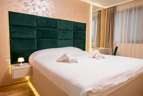 1 dormitorio con 1 cama blanca grande y cabecero verde en The BizHub (by Holiwork Stays), en Plovdiv