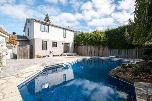 una piscina frente a una casa en Lux. 4BR House with Pool near DT, en Brossard