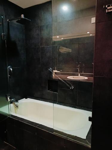 a bathroom with a bath tub and a sink at HOTEL VIRREYNAL in Teziutlán