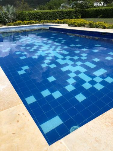 a swimming pool with blue tiles on the floor at Casa Tótem inmersión inolvidable en la naturaleza in Apulo