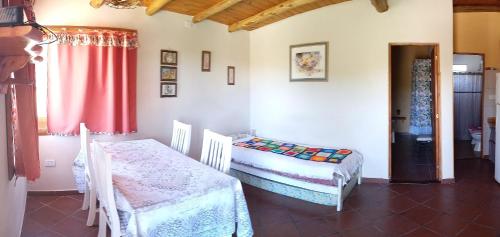 Habitación con 2 camas y cortina roja. en Cabañas Monika - Alta en Huerta Grande
