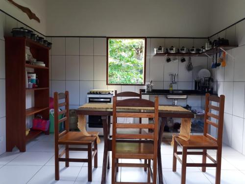 uma cozinha com uma mesa de madeira e cadeiras em Casa da Jane em Paraty