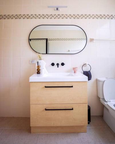 a bathroom with a sink and a mirror at Nunyara - Mountain Views, Rural, Kangaroos, Birds in Newnes Junction