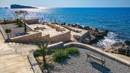una playa con un montón de bancos y el océano en Sunset Bay Apartments, en Utjeha