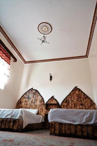a bedroom with two beds and a clock on the ceiling at Dounia Hostel in Tinerhir