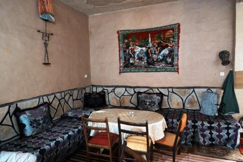 a living room with a couch and a table with chairs at Dounia Hostel in Tinerhir