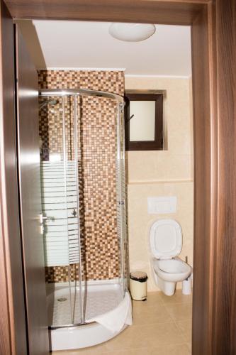 a bathroom with a toilet and a glass shower at Nobel Residence in Mamaia Sat/Năvodari
