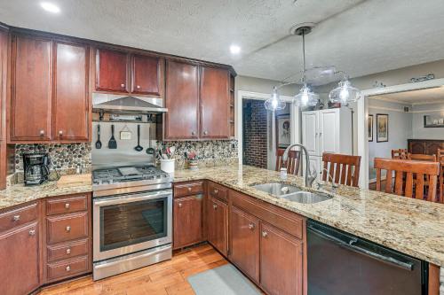 a kitchen with wooden cabinets and stainless steel appliances at Midway Home on 22 Acres Near Bourbon Trail! in Frankfort