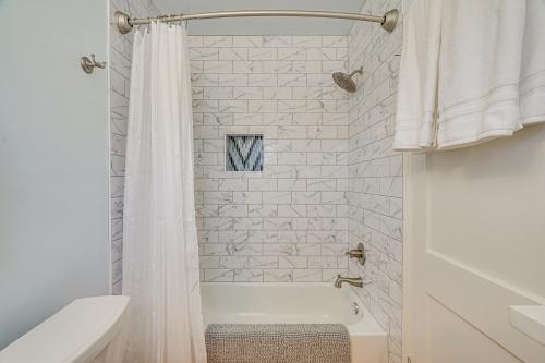 a white bathroom with a white tub and a shower at Ideally Located Tucson Townhome 2 Mi to Downtown! in Tucson