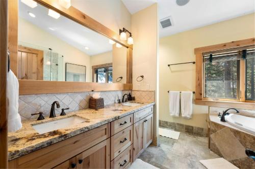 baño con 2 lavabos y espejo grande en Emerald Retreat on the West Shore - 3 BR with Hot Tub, Pool Table, Wooded Views en Homewood