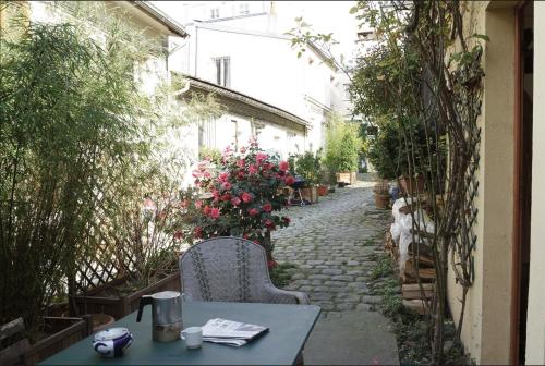 an alley with a table and chairs and flowers at Maison sur cour in Paris