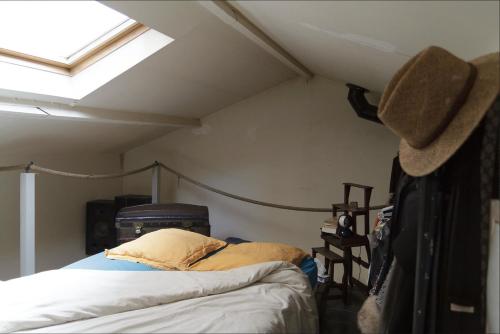 sypialnia z łóżkiem z kapeluszem w obiekcie Maison sur cour w Paryżu