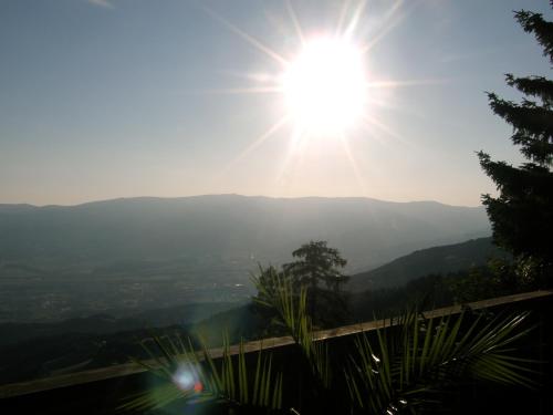 a sun is shining over a mountain range at Hotel Garni Gästehaus Karin in Sankt Stefan im Lavanttal