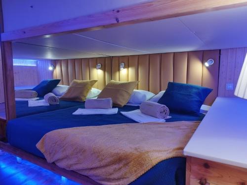 a bedroom with two beds with blue and yellow pillows at SLEEPBOAT LuxLife Yatch in Porto