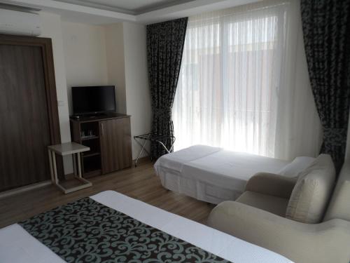 ŞarköyにあるZen Inn Boutiqueのベッド、ソファ、窓が備わるホテルルームです。