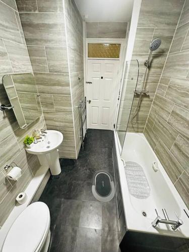 y baño con aseo, lavabo y bañera. en Luxurious & modern large house 9mins drive to town en Beeston Hill