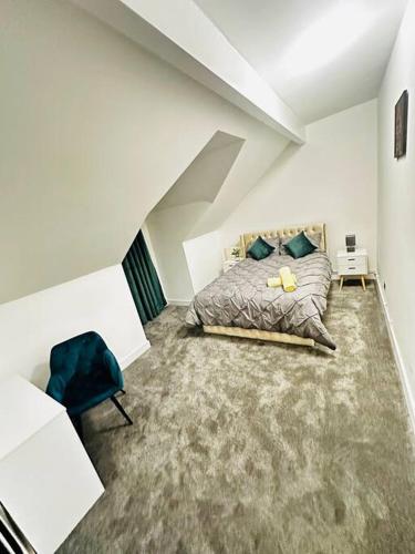 1 dormitorio con 1 cama y 1 silla azul en Luxurious & modern large house 9mins drive to town en Beeston Hill