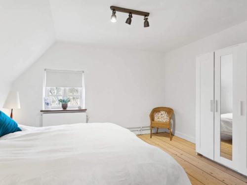 a white bedroom with a bed and a window at 7 person holiday home in Tranekær-By Traum in Tranekær