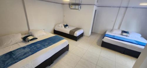 a room with three beds in a room at Edificio Regata INN in Buenaventura