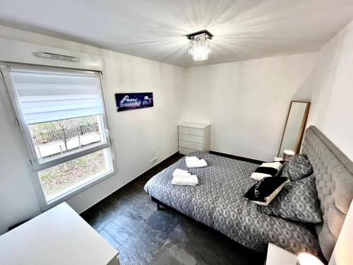 um pequeno quarto com uma cama e uma janela em GRAND F2 A 5 MIN A PIEDS DE LA GARE em Vigneux-sur-Seine