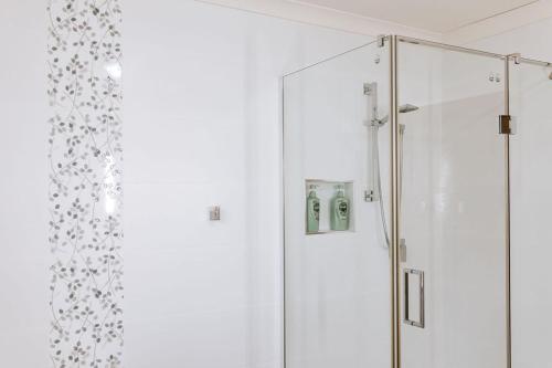 a bathroom with a shower and a glass door at Relax @ 31 - Location Location! in Bicheno