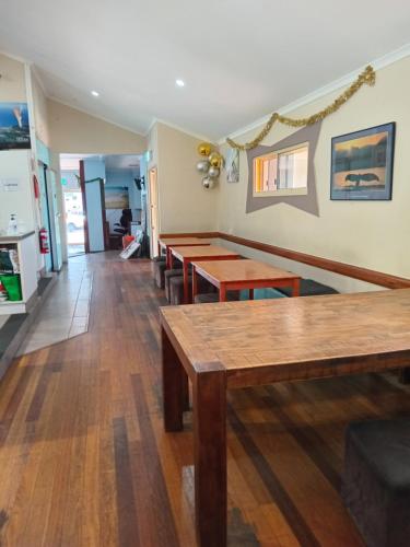 a dining room with wooden tables and benches at Hervey Bay Flashpackers in Hervey Bay