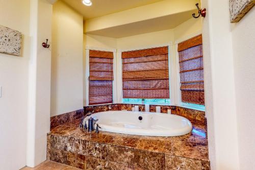 Habitación con ventanas y baño con bañera. en Surendra Lodi Farmhouse en Lodi