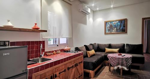 a living room with a couch and a kitchen at Aparthotel Dar Nowara Chaouen in Chefchaouene