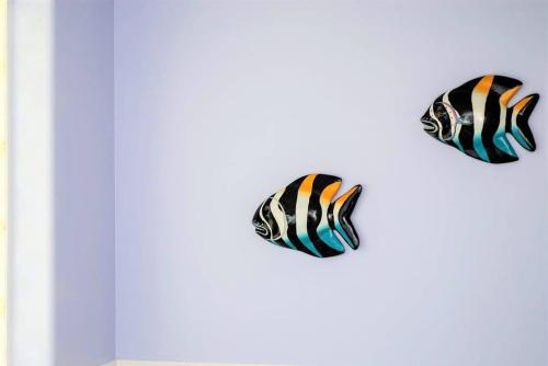 three fish kites hanging on a wall at On The Bay in North Side