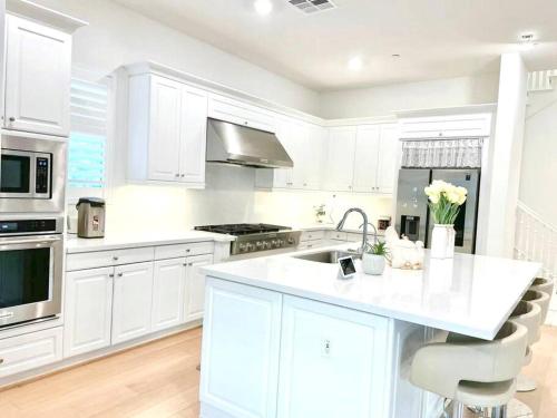 uma cozinha branca com um lavatório e um fogão em Refined Luxury Living in the Heart of Irvine! em Irvine