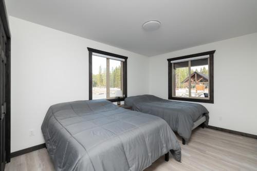 duas camas num quarto com duas janelas em The Sundance Cabin em Valemount