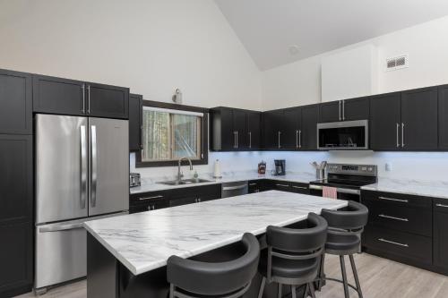 a kitchen with black cabinets and a marble counter top at The Sundance Cabin in Valemount