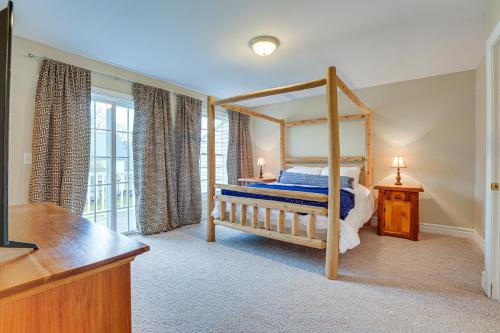 a bedroom with a canopy bed with a wooden bed frame at Ellicottville Townhome with Hot Tub about 2 Mi to Skiing in Ellicottville