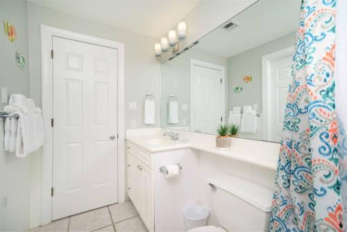 a bathroom with a sink and a toilet and a mirror at On The Bay in North Side