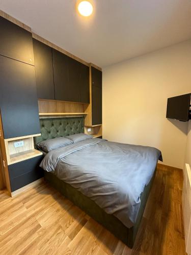 um quarto com uma cama grande num quarto em Sofija Apartman Zlatibor em Zlatibor