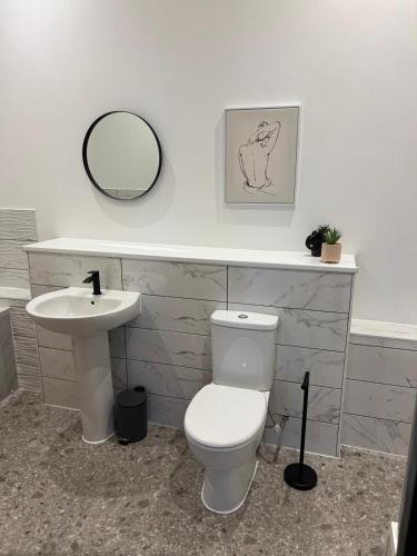 uma casa de banho com um WC branco e um lavatório. em StayRight Elegant Kingsway Studio #5 - Central Location em Swansea