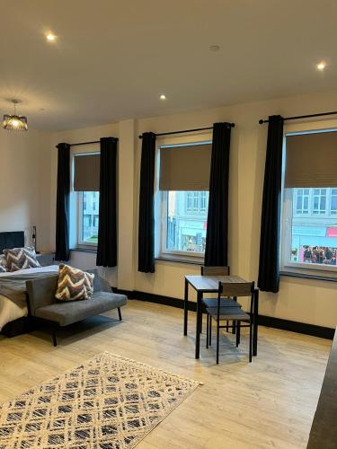 um quarto com uma cama, uma mesa e janelas em StayRight Elegant Kingsway Studio #5 - Central Location em Swansea