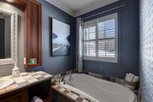 une salle de bain avec une baignoire, un lavabo et une fenêtre dans l'établissement Stunning Waterfront Chalet A Lot Of Natural Light, à Saint-Zénon