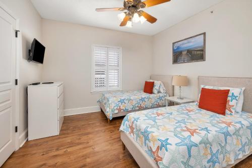 a bedroom with two beds and a ceiling fan at St. Simons Grand # 307 in Saint Simons Island