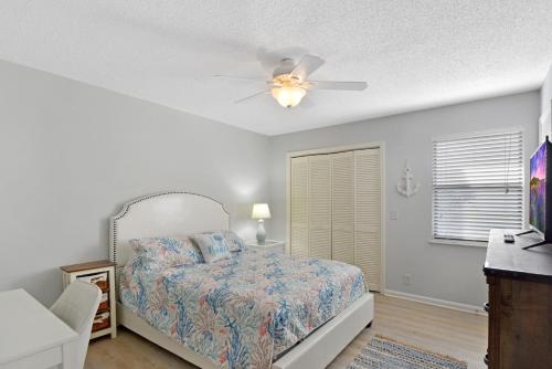 a bedroom with a bed and a ceiling fan at Coral Cottage in Saint Simons Island