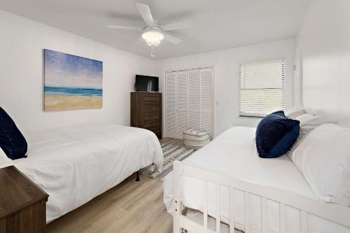 a bedroom with two beds and a ceiling fan at Selah in Saint Simons Island