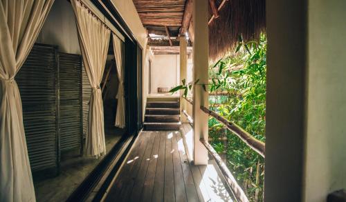 a hallway of a house with a wooden floor and stairs at Orchid House Tulum Jungle in Tulum