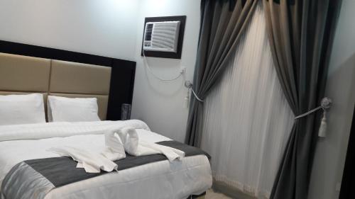 een hotelkamer met 2 bedden en een raam bij اريس الشرق للشقق المخدومة in Jeddah