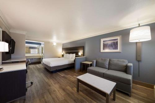 una sala de estar con cama y sofá y una habitación con cama en Best Western Inn & Suites Lemoore en Lemoore
